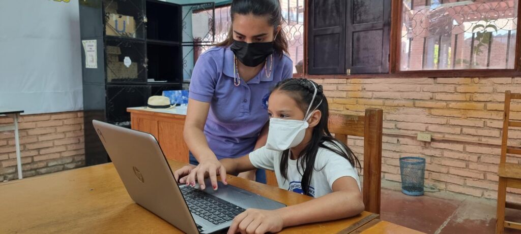 niña con profesora en aula de NPH Honduras
