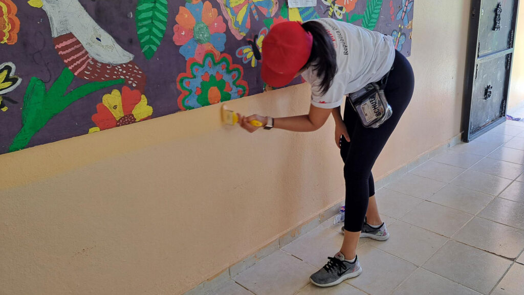 Chica pintando pared en NPH Guatemala