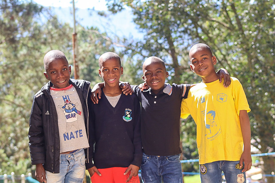 Niños y niñas de NPH Haití jugando al aire libre en un espacio protegido.