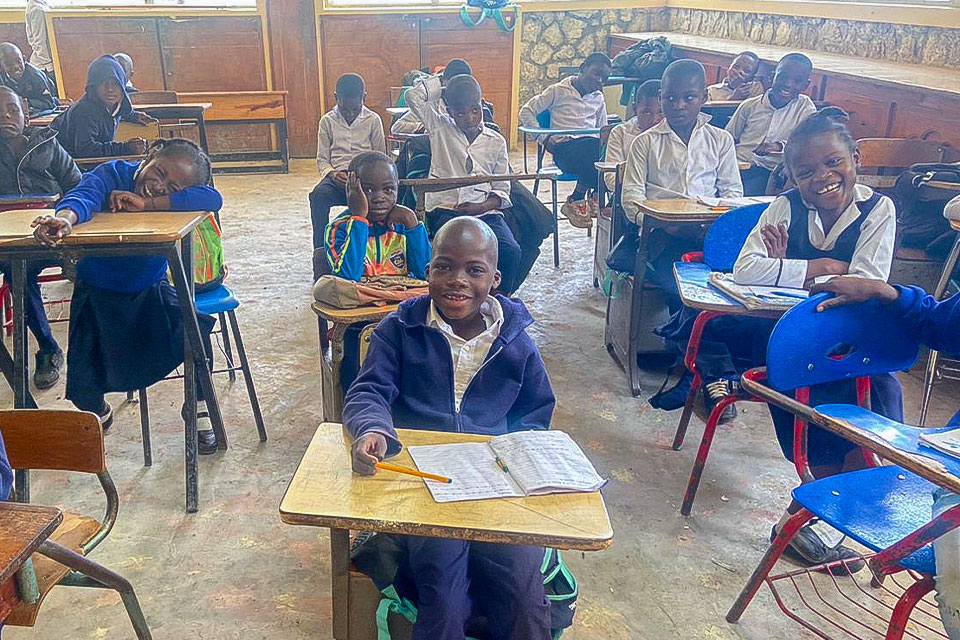 Alex en el aula de la escuela Ste. Helene, participando en una actividad educativa junto a otros niños.