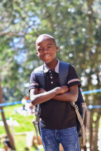 Niño de 7 años sonriendo en un centro educativo de NPH Haití, en un entorno seguro y cuidado.