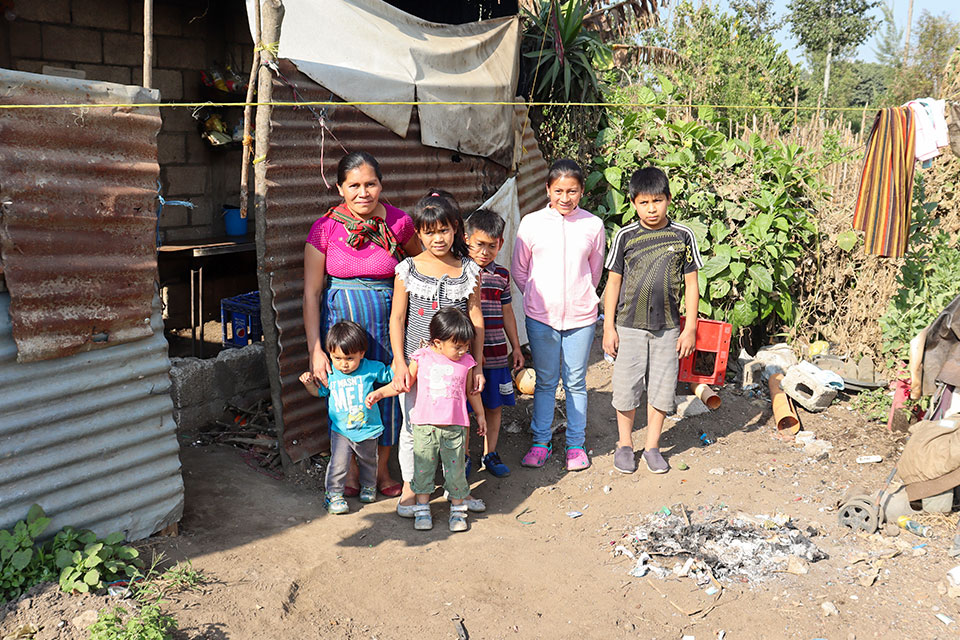 Martin junto a sus hermanos y su mamá delante de su casa.