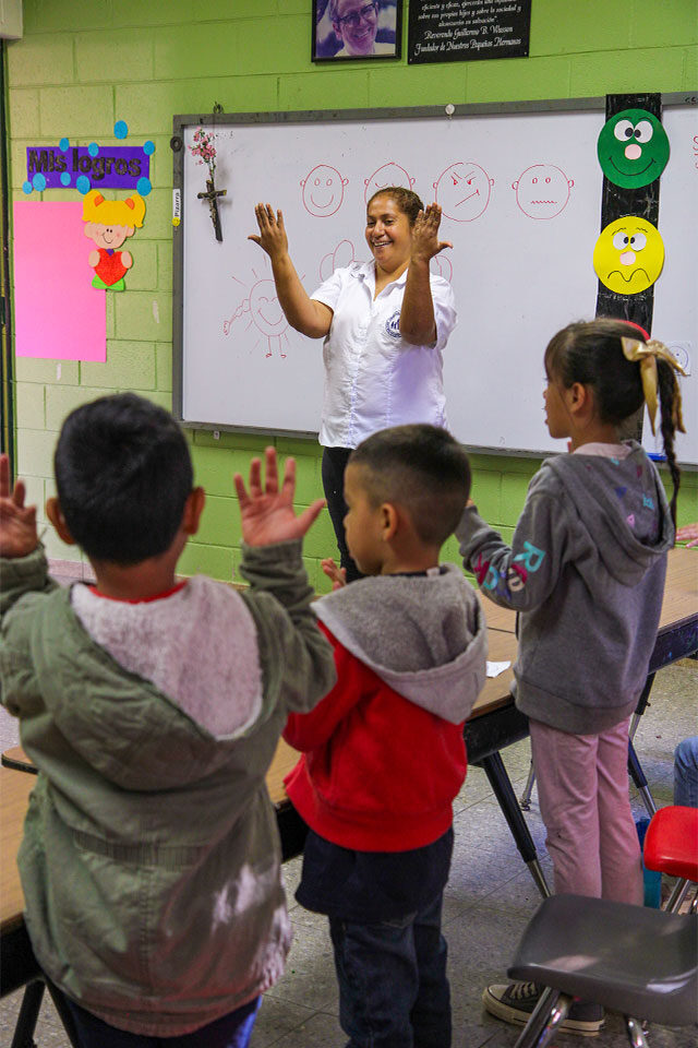 Sandra acompañando una actividad educativa con niños y niñas en un aula de NPH El Salvador.
