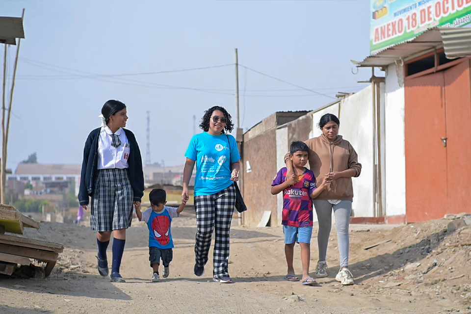 Sahori camina con su familia y la trabajadora social del Centro Familiar Comunitario de NPH Peru en su comunidad.